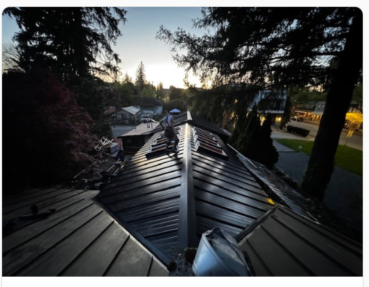 After: completed standing seam metal roof on the same Vancouver character home at dusk by Roofking